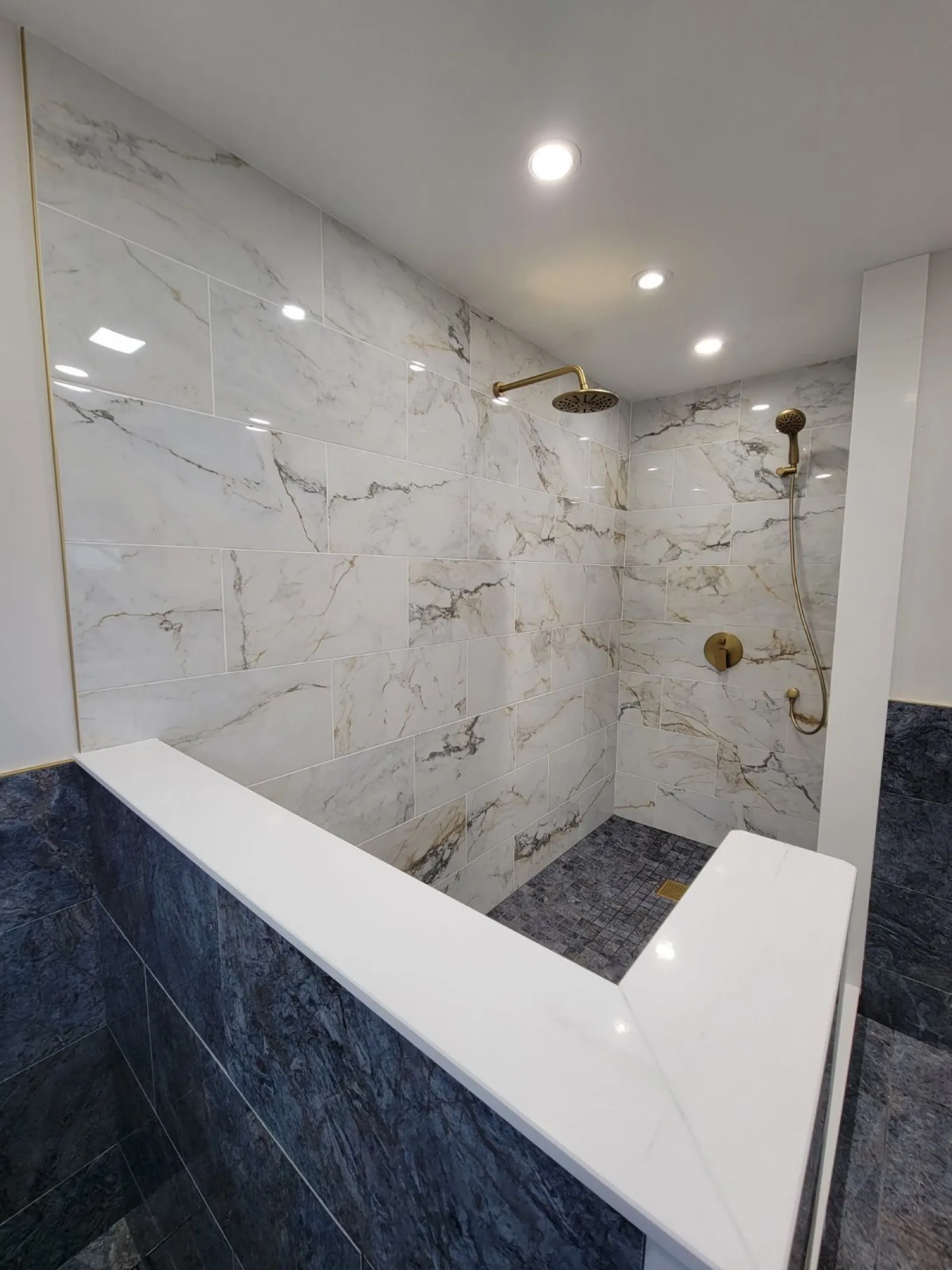Marble look tile shower with bench after a bathroom remodel