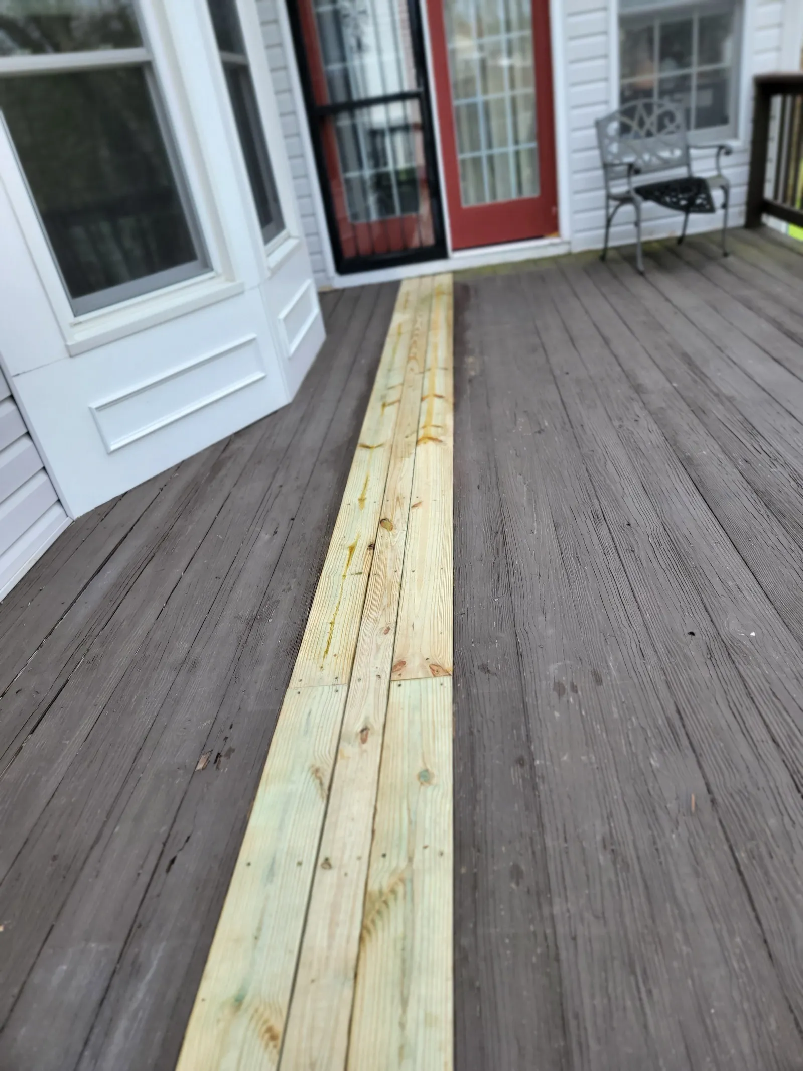 New deck boards laid in next to weathered decking