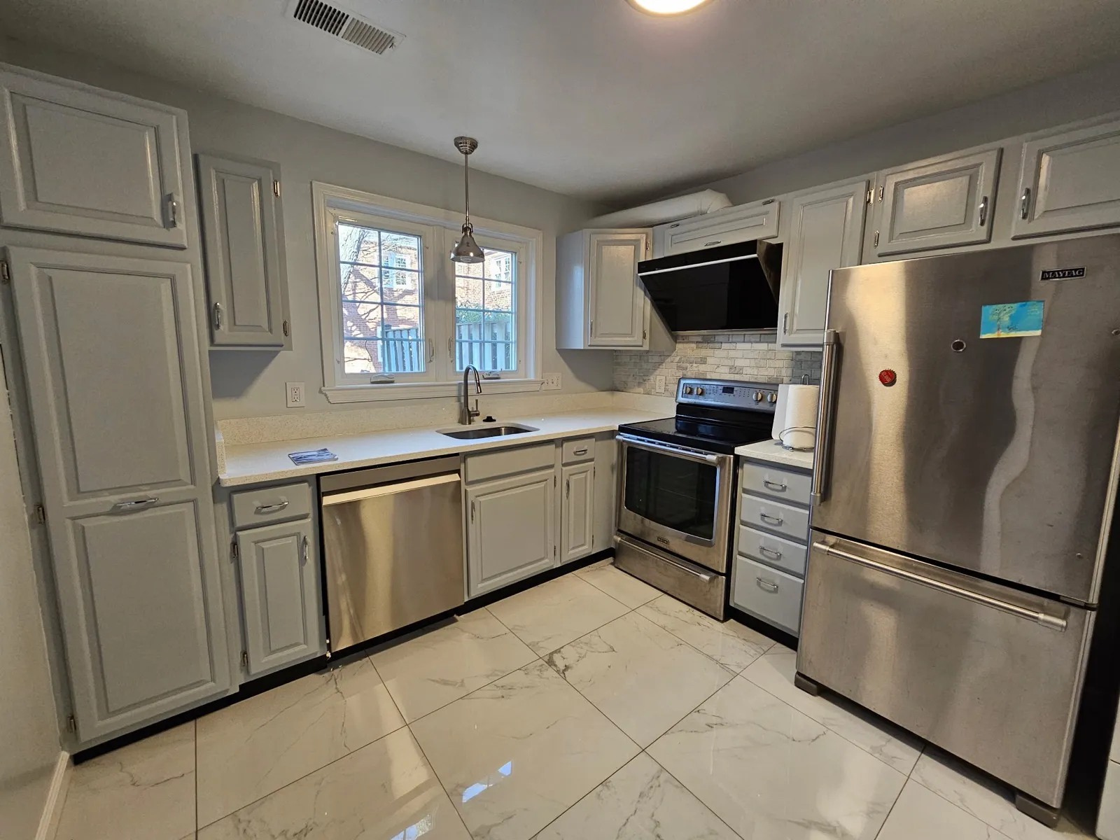 Finished kitchen with white cabinets and stainless appliances