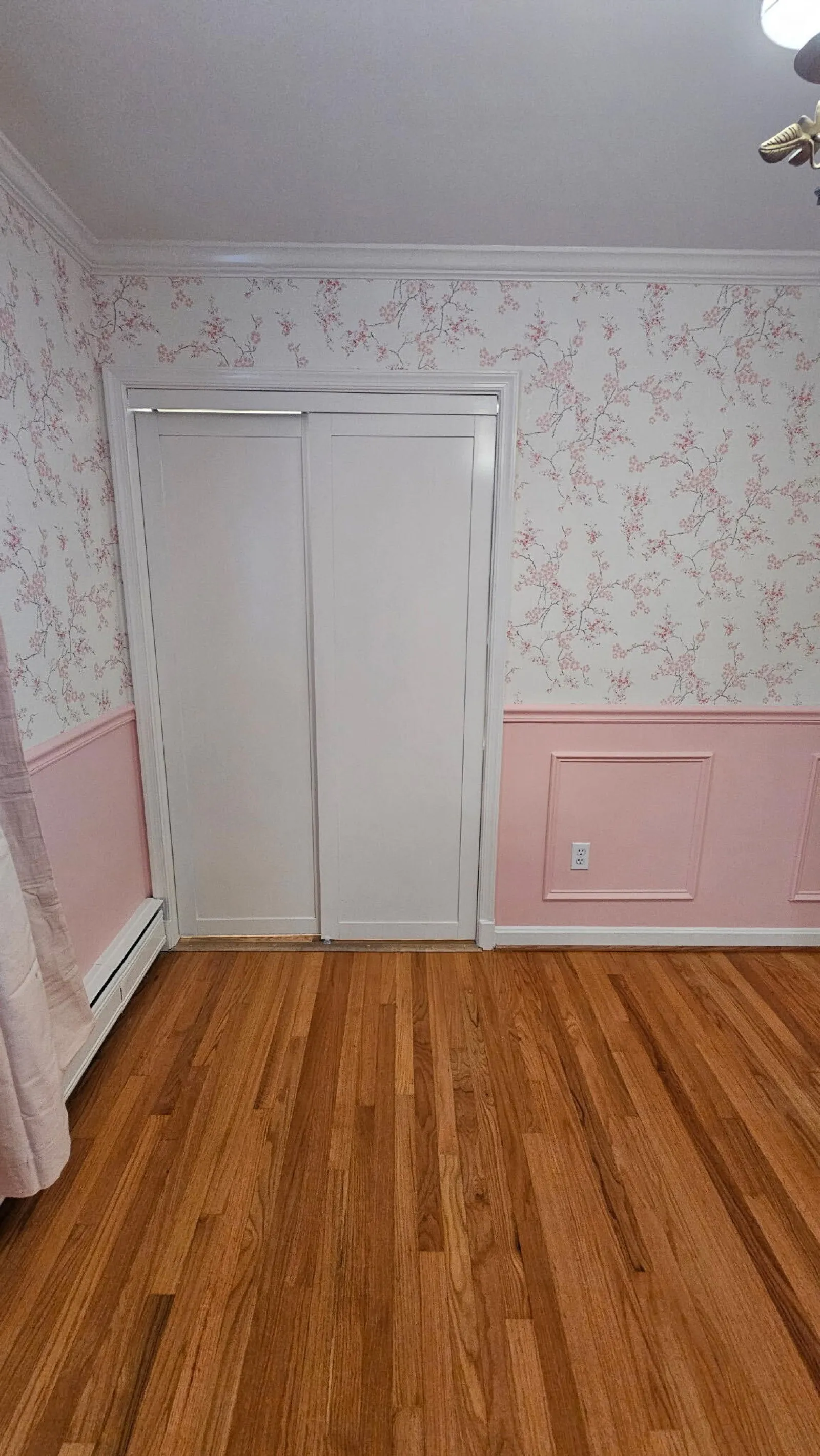 Floral wallpaper and two tone paint with wainscoting in a bedroom